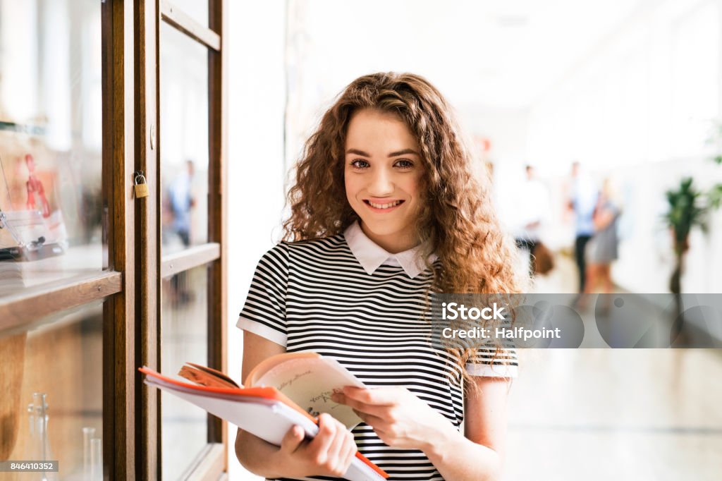 Adolescente con los portátiles en pasillo de la escuela secundaria durante las vacaciones. - Foto de stock de Estudiante de secundaria libre de derechos