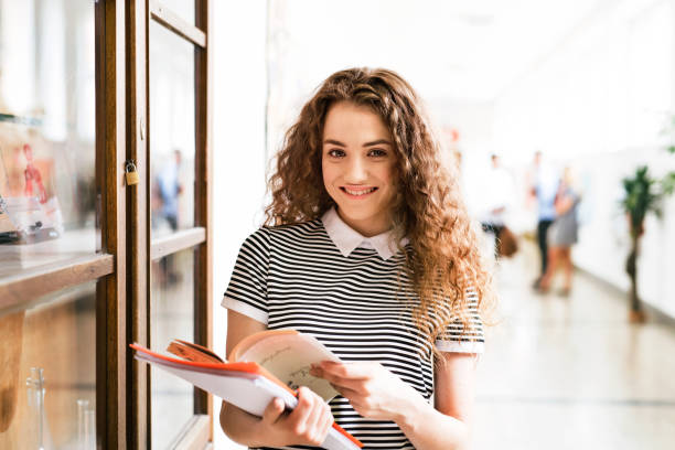 adolescente con los portátiles en pasillo de la escuela secundaria durante las vacaciones. - college girl fotografías e imágenes de stock