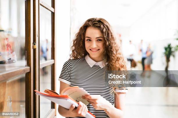 Adolescente Con Los Portátiles En Pasillo De La Escuela Secundaria Durante Las Vacaciones Foto de stock y más banco de imágenes de Estudiante de secundaria