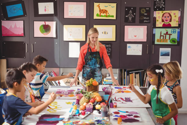 istock Teacher assisting schoolkids in drawing class 846410354