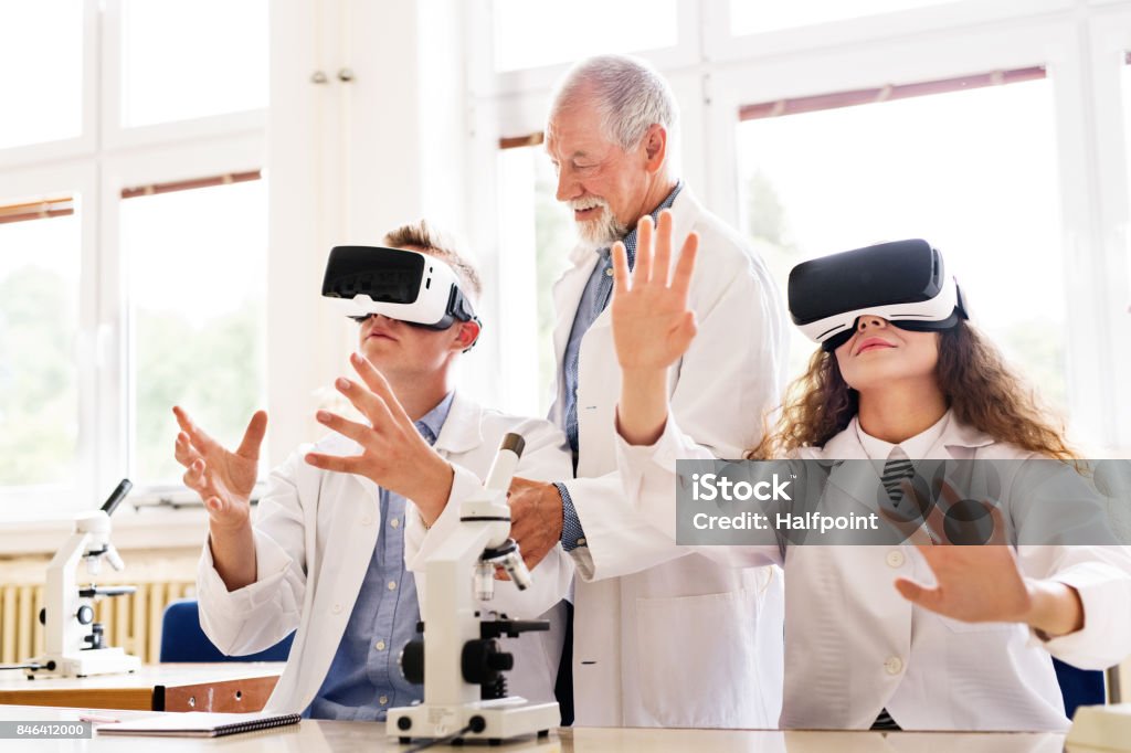 Senior teacher teaching biology to high school students Senior teacher teaching biology to his high school students with virtual reality glasses in laboratory. Virtual Reality Stock Photo