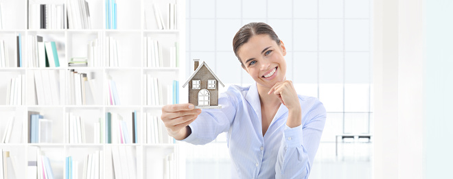 home concept smiling woman showing house model, real estate and design