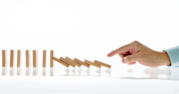 istock Businessman hand pushing domino pieces 846415798