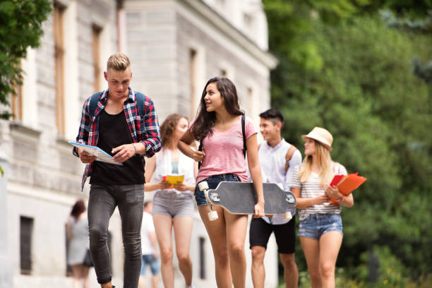 grupo de estudantes adolescentes atraentes, caminhando para a universidade. - tall short men women - fotografias e filmes do acervo