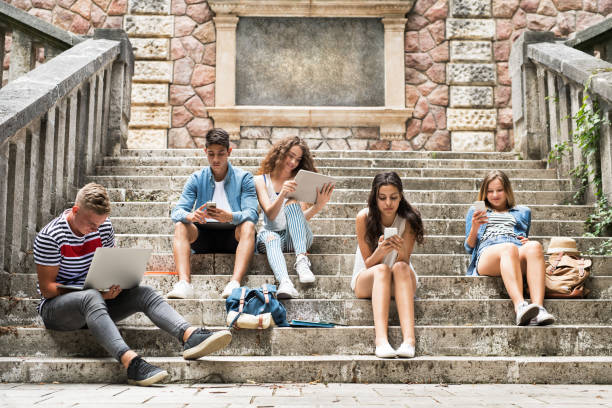 alumnos adolescentes con gadgets fuera de escalones de piedra. - adicto grupo de jóvenes amigos usando teléfonos móviles fotografías e imágenes de stock