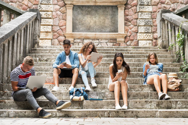 istock Teenage students with gadgets outside on stone steps. 846419328