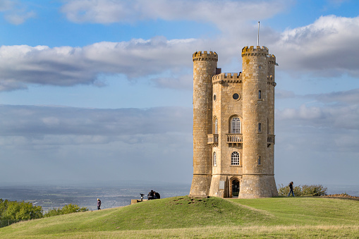 Figures giving some scale against the historic Broadway Tower. It is a folly on Broadway Hill, near the village of Broadway, in the English county of Worcestershire, at the second-highest point of the Cotswolds. Broadway Tower's base is 1,024 feet above sea level. The second highest after Cleeve Hill at 1,083 feet (330 m).