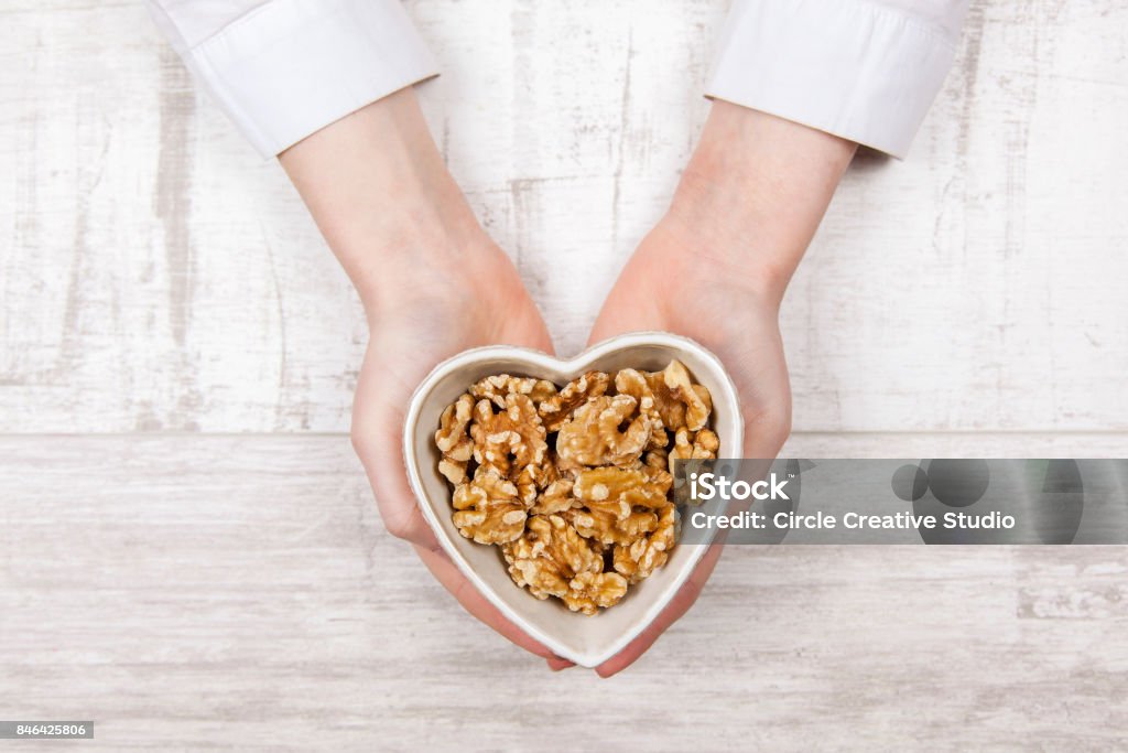 Walnuts in woman hands Walnuts in woman hands on white background. Walnut Stock Photo