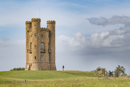 Lone figure looking up, giving some scale against the historic Broadway Tower in Broadway, The Cotswolds, which sits high on the Cotswold escapment at 1024 feet (312m) above sea level. The second highest after   Cleeve Hill at 1,083 feet (330 m)