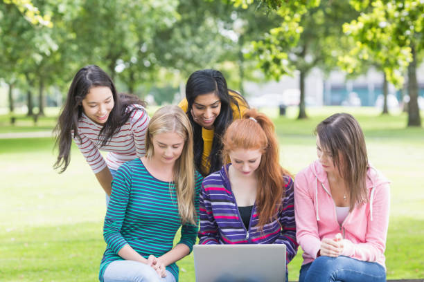istock College girls using laptop in the park 846428922