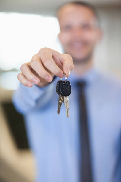 istock Salesman holding car keys by his fingertips 846436960