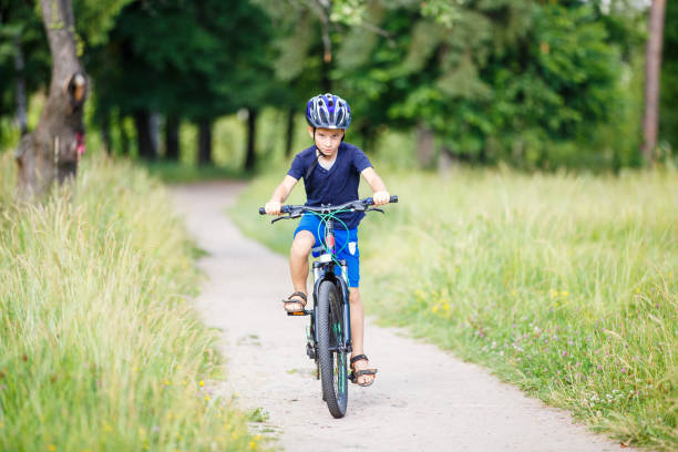 istock Small boy in helmet riding bicycle in park 846444870