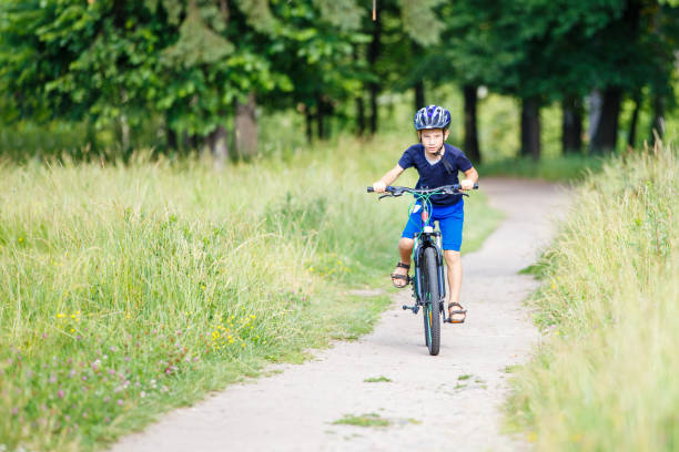 istock Small boy in helmet riding bicycle in park 846445020
