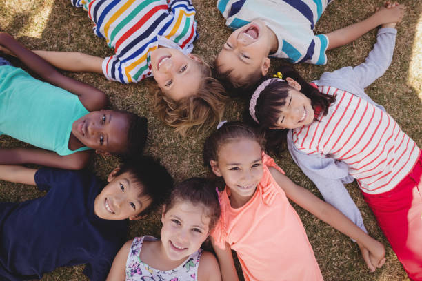 istock Overhead view of schoolkids lying on grass 846445036