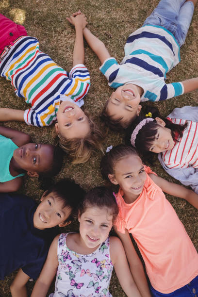 istock Overhead view of schoolkids lying on grass 846445060