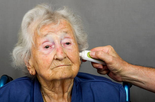 Cittadino anziano con temperatura presa - foto stock