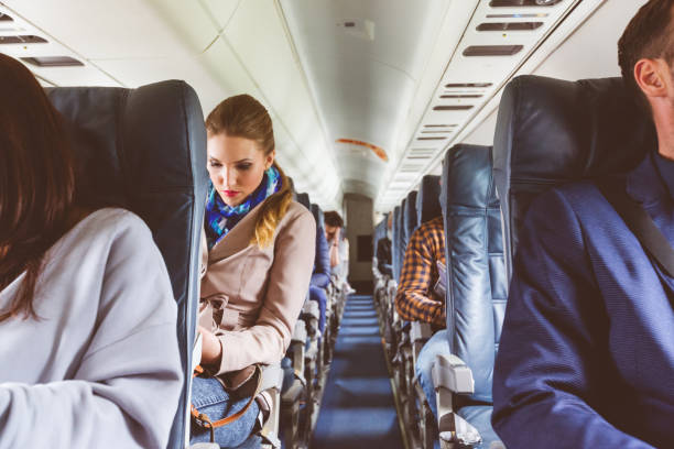 Passengers on seat during flight Interior of airplane with people sitting on seats. Passengers on seat during flight. airplane interior stock pictures, royalty-free photos & images