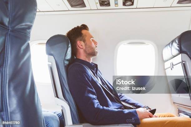 Businessman Traveling By Flight Stock Photo - Download Image Now - Airplane, Men, Window