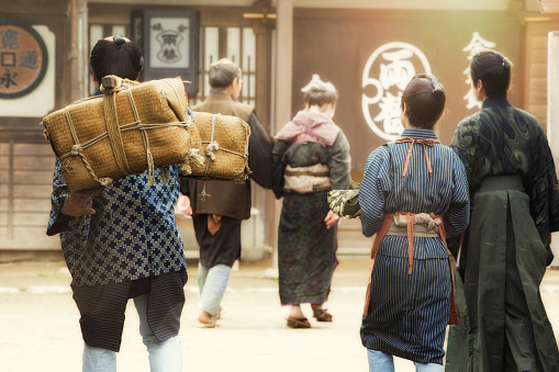 Rear view of small group of Japanese actors reenacting Edo period village scene