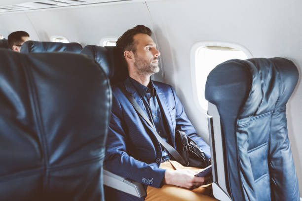 hombre de negocios volando en avión - silla al lado de la ventana fotografías e imágenes de stock