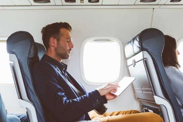 biznesmen za pomocą cyfrowego tabletu w samolocie - commercial airplane airplane business travel flying zdjęcia i obrazy z banku zdjęć