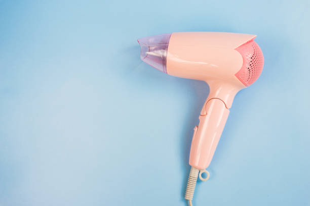 istock Pink hair dryer on light blue background with copy space for text insertion or decoration, woman beauty care concept 846463032