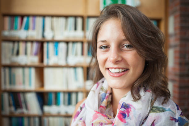 istock Smiling female student against bookshelf in library 846466666