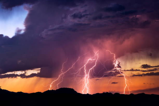 lightning bolts strike from a sunset storm - trovão imagens e fotografias de stock