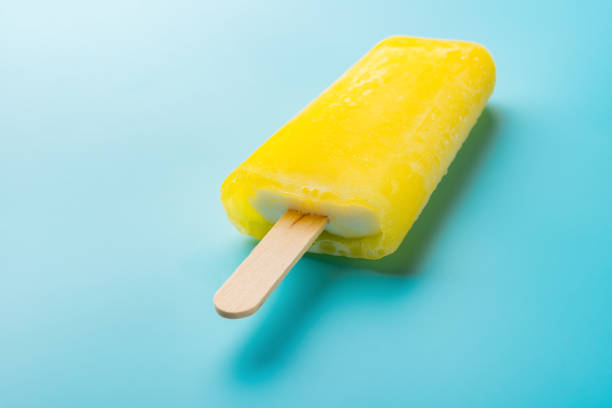 istock yellow popsicle on a blue background close up 846469678