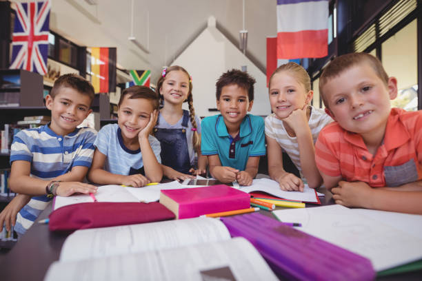istock Portrait of happy schoolkids studying at table in library 846475830