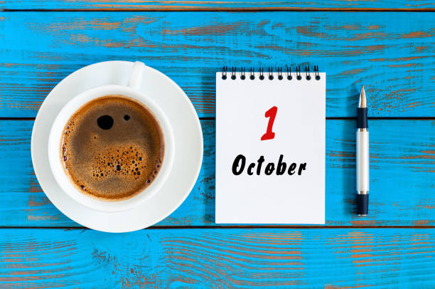 istock October 1st. Day 1 of october month. Calendar with cup morning coffee on blue table 846476366