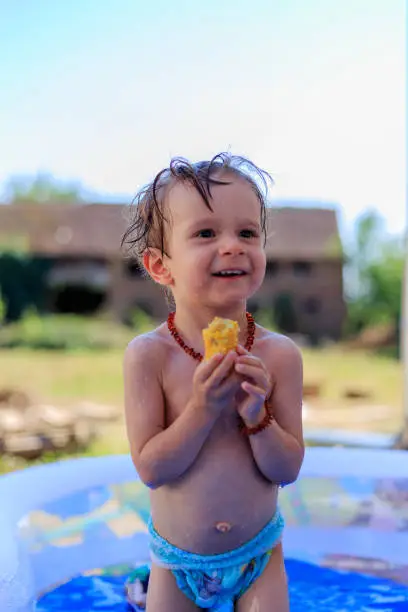 Male baby plays in the swimming pool