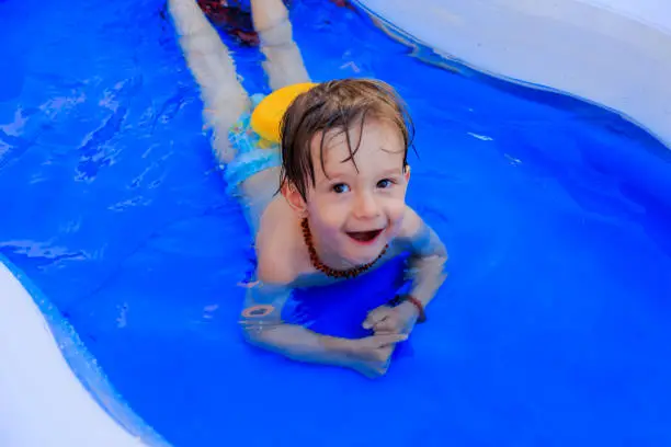 Male child plays in the swimming pool