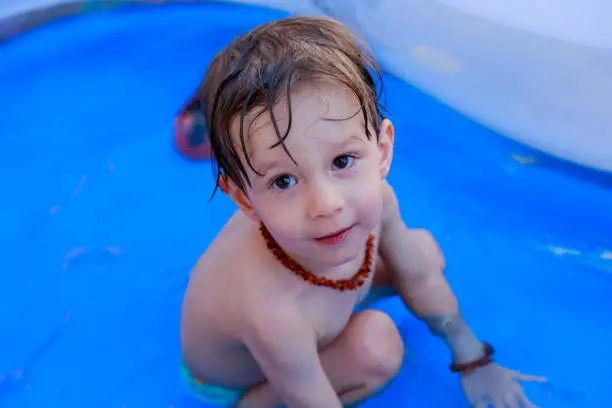 Male child plays in the swimming pool