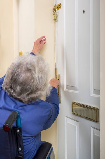 Senior Lady disabile che cerca di aprire una porta. - foto stock
