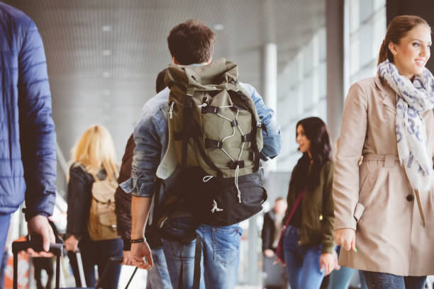istock Young man walking inside crowded airport terminal 846486036