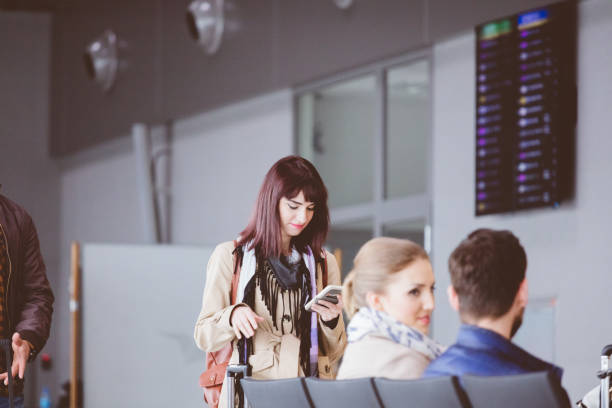 istock Young woman using mobile phone in airport terminal 846486488
