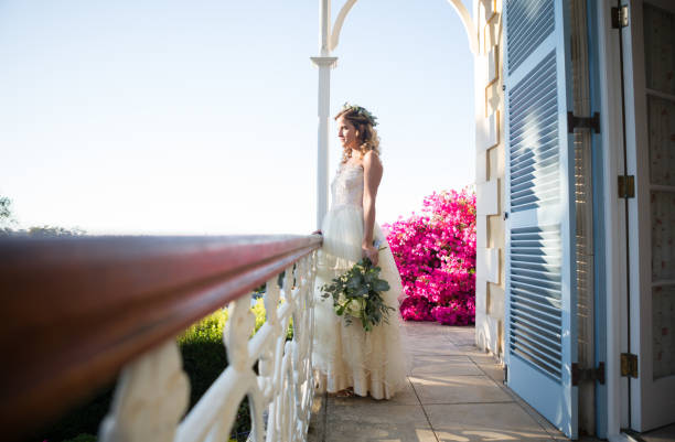 istock Pretty bride holding bouquet while standing in balcony 846495232