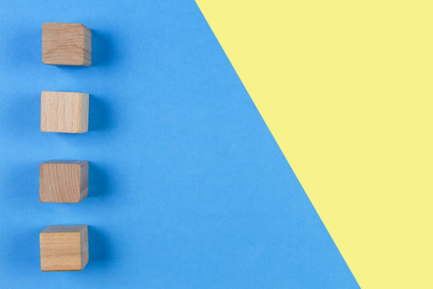 istock Wooden cubes on light blue and yellow background. Top view 846496022