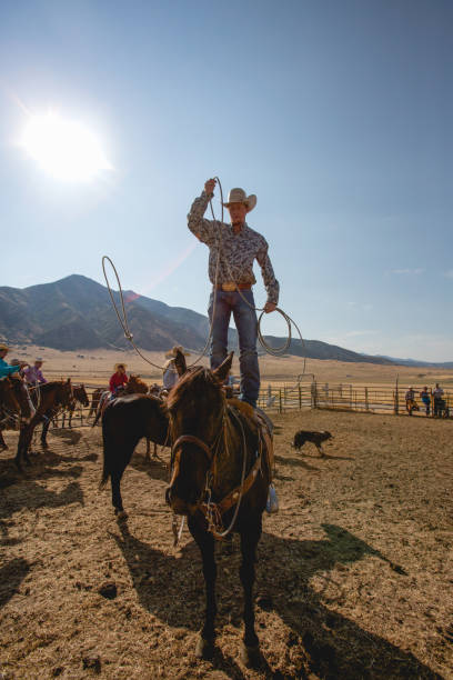 istock Young cowboy Standing on Horse Doing Rope Tricks 846502662