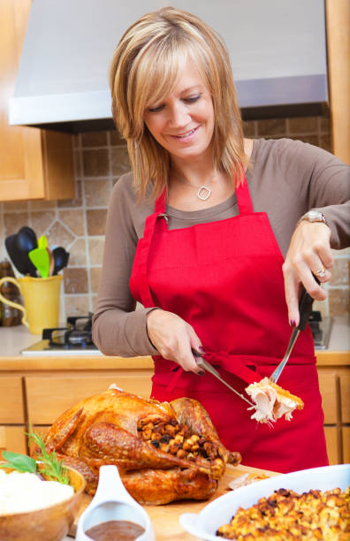 mujer talla pavo asado preparación de acción de gracias y cena de navidad - roast turkey turkey carving turkey breast fotografías e imágenes de stock