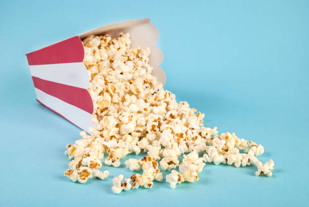 Popcorn spilled on blue background stock photo
