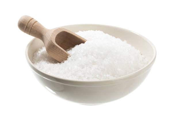 Salt crystals in ceramic bowl isolated on white background.
