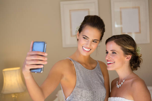 istock Bridesmaid taking selfie with bride in bedroom 846518788