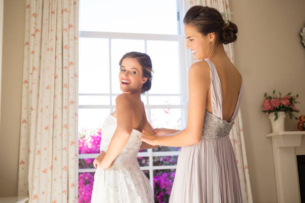 istock Bridesmaid adjusting bride wedding dress in fitting room 846518790