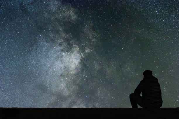 istock Milky Way. Night sky with stars and silhouette alone man looking at starry sky. 846521828
