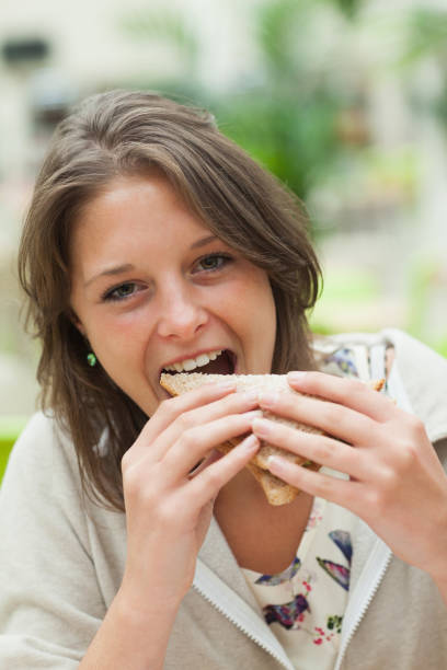 istock Female student eating sandwich in the cafeteria 846525128