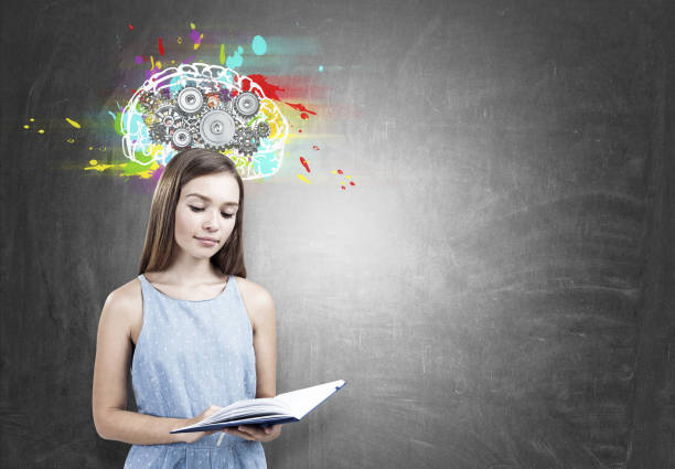 istock Teen girl holding a book, brain cogs 846526876