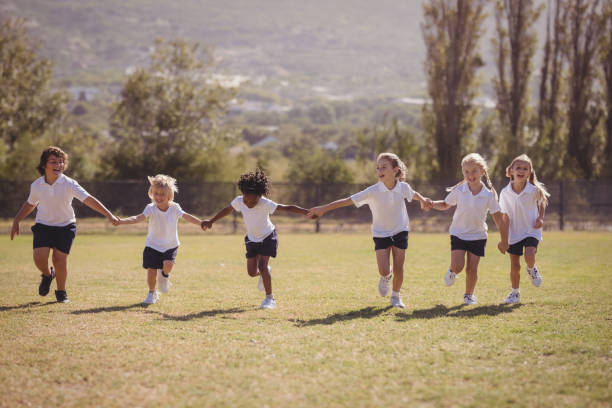 istock Schoolgirls running with hand in hand in park 846532164