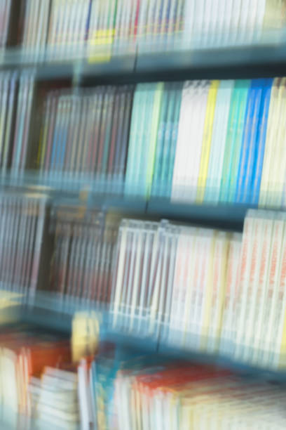 libri, manuali e libri di testo astratti sfocati su librerie in biblioteca o in libreria su sfondo verticale. concetto per l'educazione, la conoscenza, la lettura della narrativa - business blurred motion text messaging defocused foto e immagini stock